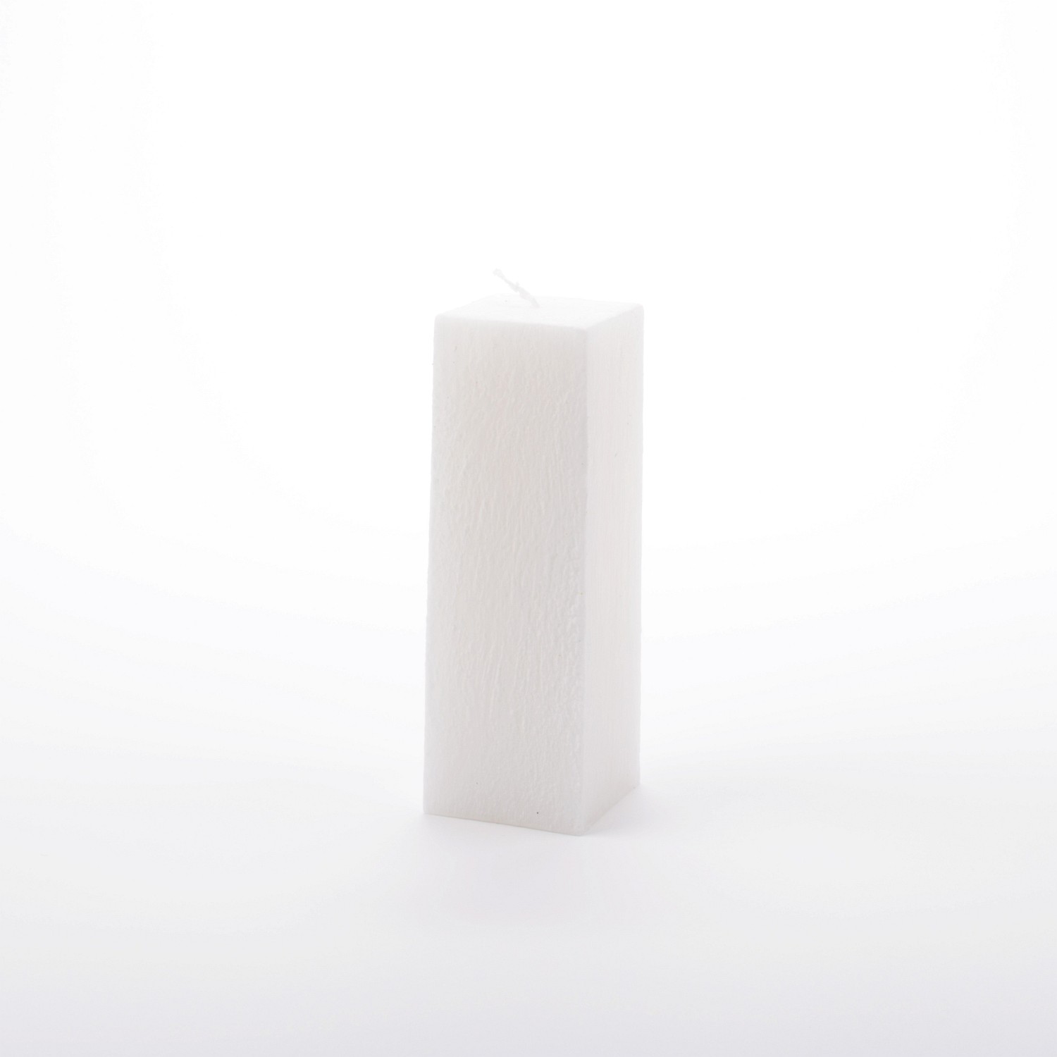 Eckige weiße Stumpenkerze mit vertikal verlaufender Struktur