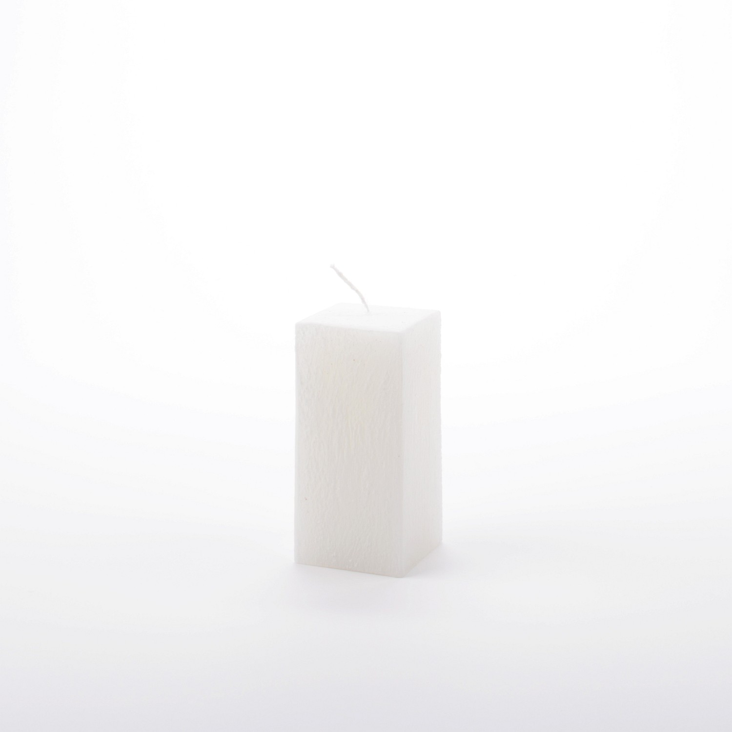 Eckige weiße Stumpenkerze mit vertikal verlaufender Struktur