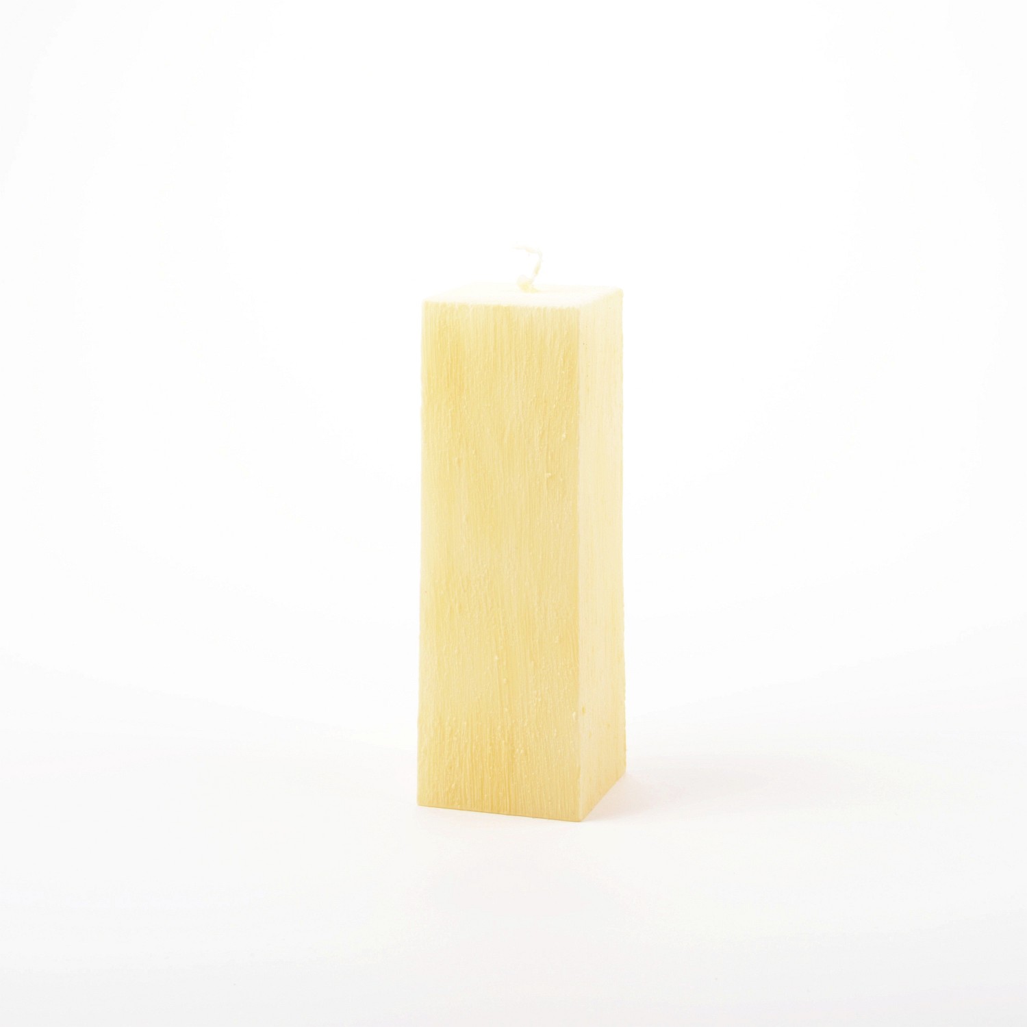 Eckige zitronenfarbene Stumpenkerze mit vertikal verlaufender Struktur